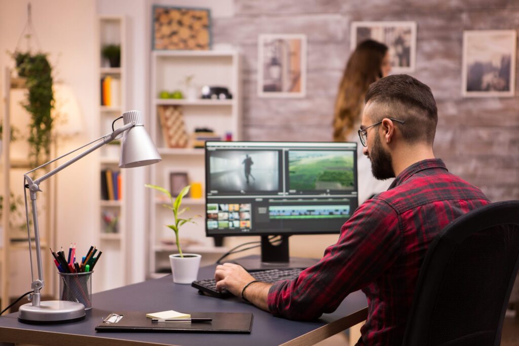Editor revisa una secuencia de vídeo en un monitor dentro de una sala con estanterías