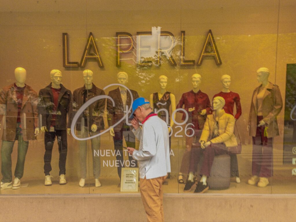 Man looking at mannequins in a store window