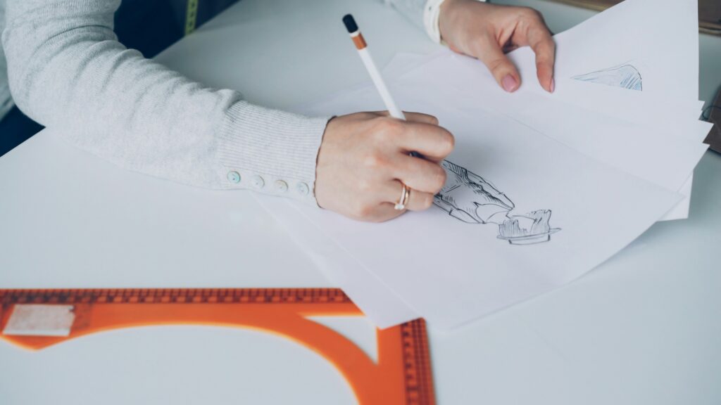 Someone is sketching a design on paper.