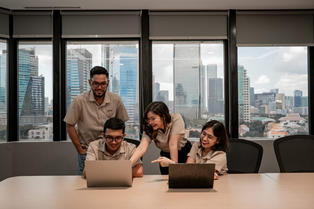 Team collaborating on laptops in modern office