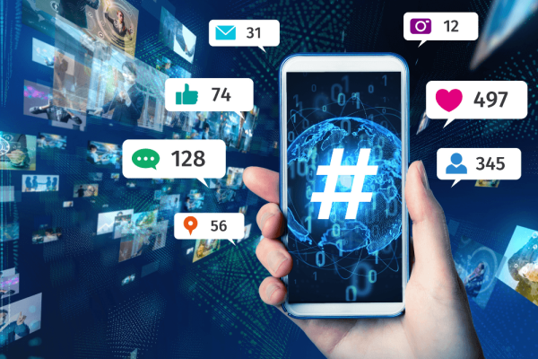 Mano sostiene un móvil del que salen burbujas con cifras de likes, comentarios y seguidores